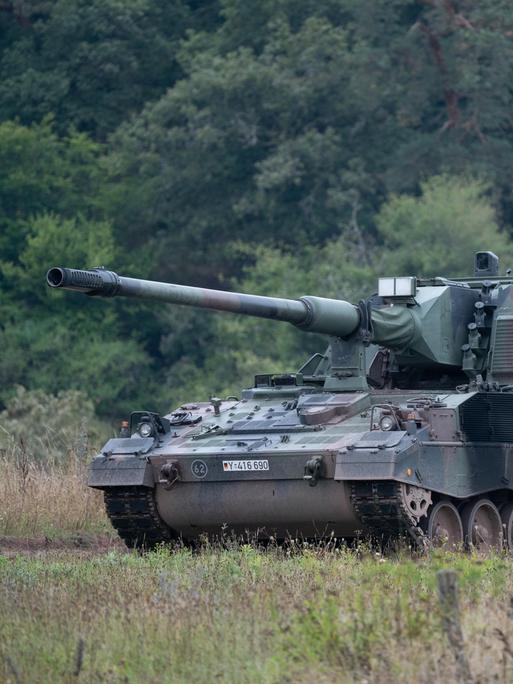 Eine Panzerhaubitze 2000 der Bundeswehr fährt durch ein Übungsgelände.