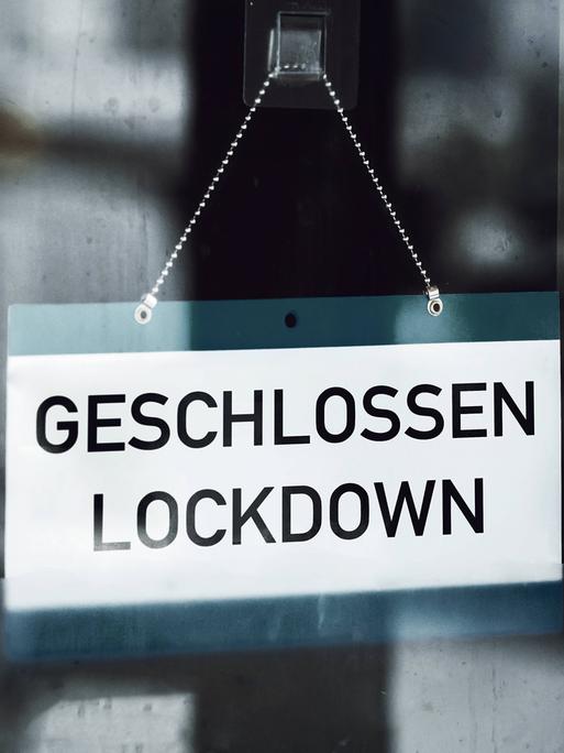 Auf einem Schild, das im Fenster eines Geschäfts hängt, steht „Geschlossen – Lockdown“. 