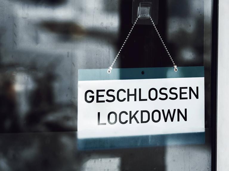 Auf einem Schild, das im Fenster eines Geschäfts hängt, steht „Geschlossen – Lockdown“. 