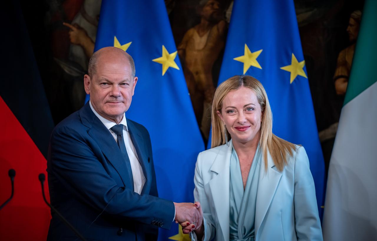 Das Foto zeigt Bundeskanzler Olaf Scholz und Giorgia Meloni, Ministerpräsidentin von Italien. Die beiden Politiker posieren für ein Foto. Scholz reicht Meloni die Hand. 