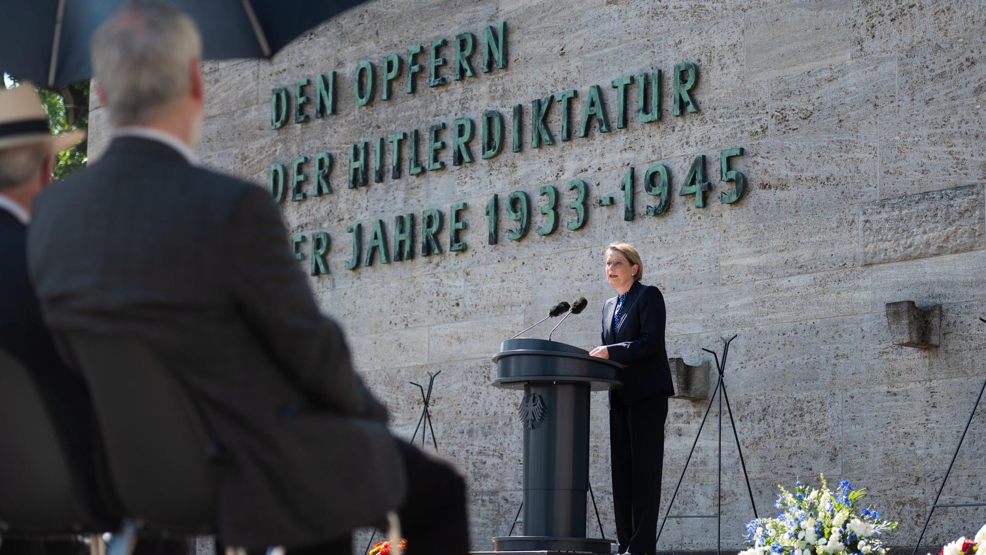 Bundesjustizministerin Hubig (SPD) steht hinter einem Mikrofon vor der Gedenkstätte Berlin-Plötzensee. Hinter ihr ist zu lesen: "Den Opfern der Hitlerdiktatur der Jahre 1933 bis 1945"