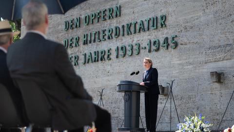Bundesjustizministerin Hubig (SPD) steht hinter einem Mikrofon vor der Gedenkstätte Berlin-Plötzensee. Hinter ihr ist zu lesen: "Den Opfern der Hitlerdiktatur der Jahre 1933 bis 1945"
