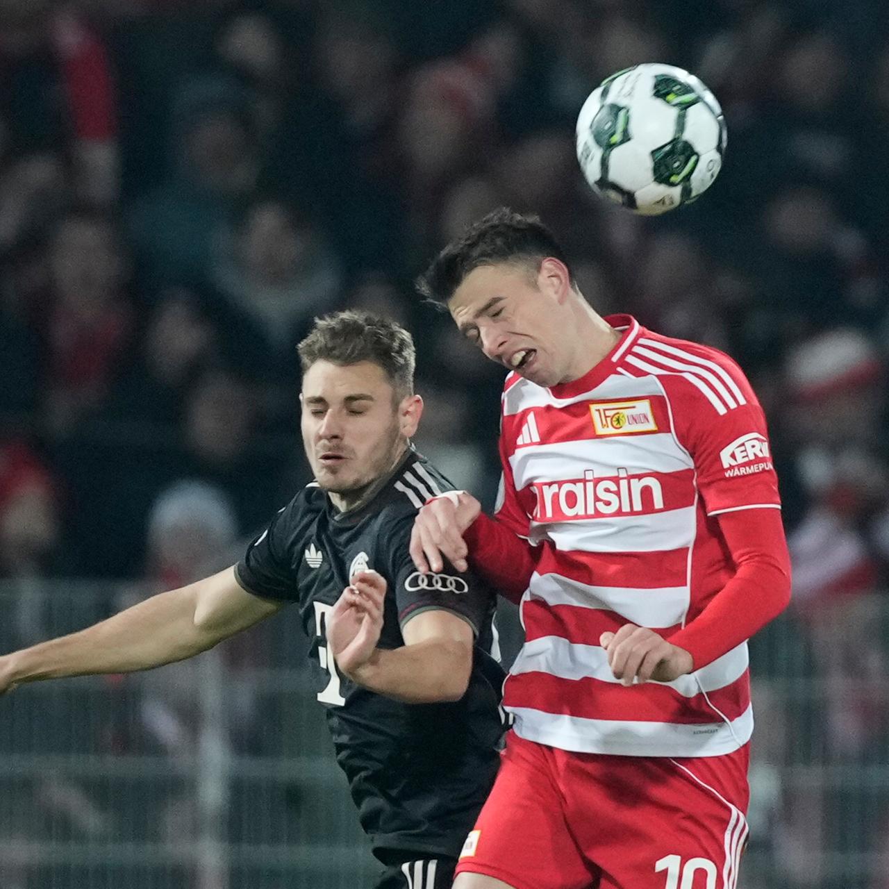 Das Foto zeigt Bayern's Josip Stanisic, links, and Ilyas Ansah von Union Berlin im Kampf um den Ball.