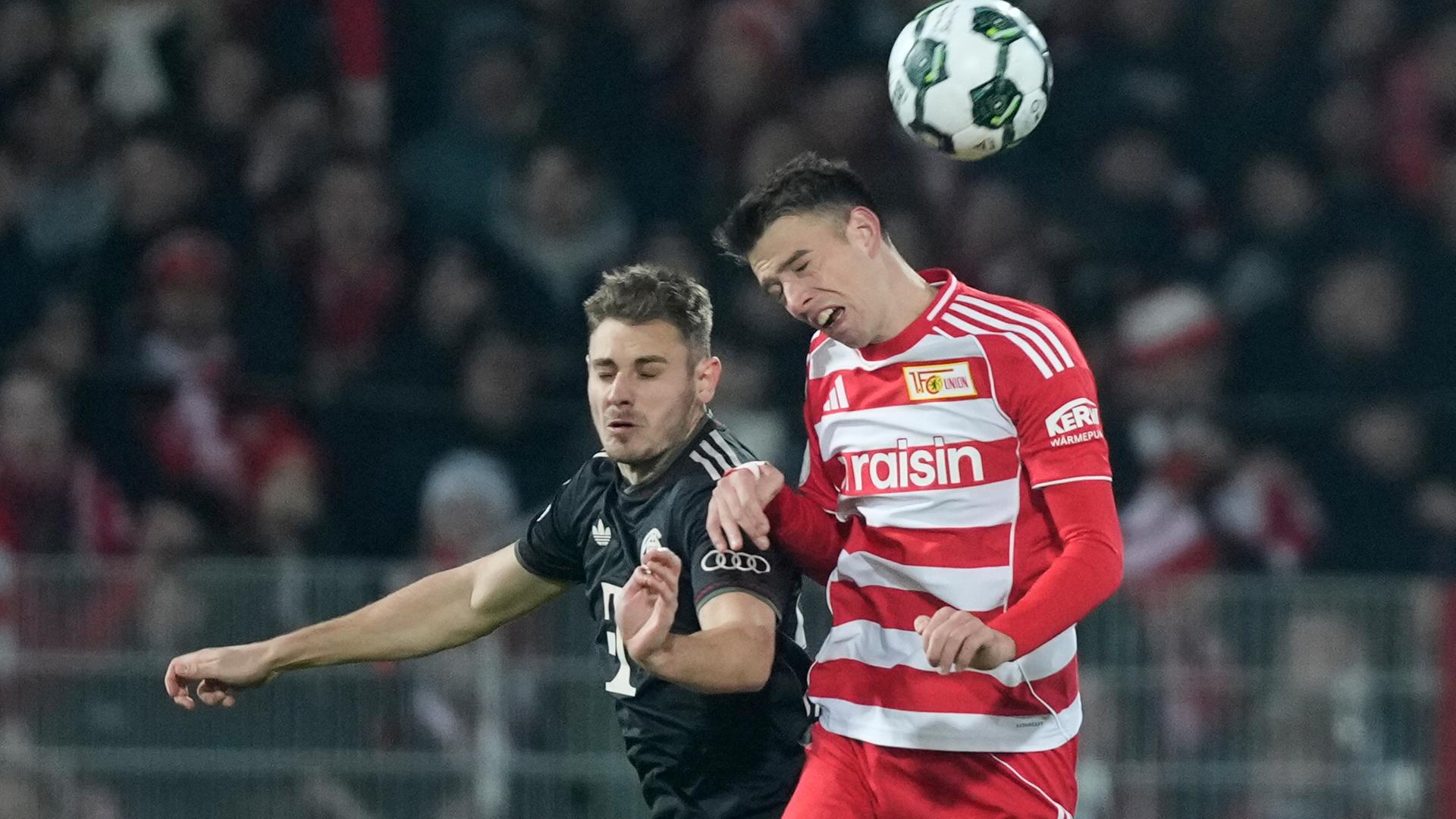 Das Foto zeigt Bayern's Josip Stanisic, links, and Ilyas Ansah von Union Berlin im Kampf um den Ball.