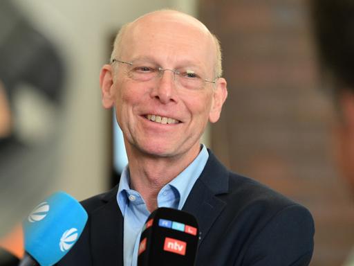 Der Kläger und Missbrauchsbetroffene Georg Menne steht vor Medienvertretern im Foyer des Gerichtsgebäudes. 