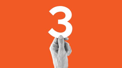 Eine Hand vor orangenem Hintergrund, die eine große 3 hochhält