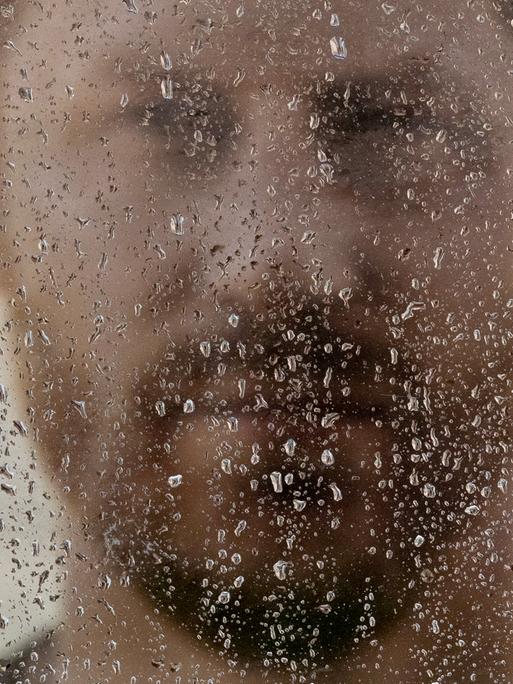 Werbeanzeige von Prinz Harrys Buch "Spare" an einem regnerischen Tag in einer Filiale von WH Smith gegenüber von Schloss Windsor. Zu sehen ist ein unscharfes Portrait von Harry hinter eine Scheibe mit Regentropfen.