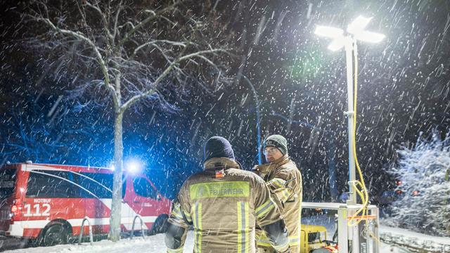 Einsatzkräfte der Berliner Feuerwehr stehen vor einem Generator-Lichtmast an einer Katastrophenschutz-Kontraktstelle vor der Carl-Schuhmann-Sportanlage im Stadtteil Lichterfelde während des Stromausfalls im Januar 2026.