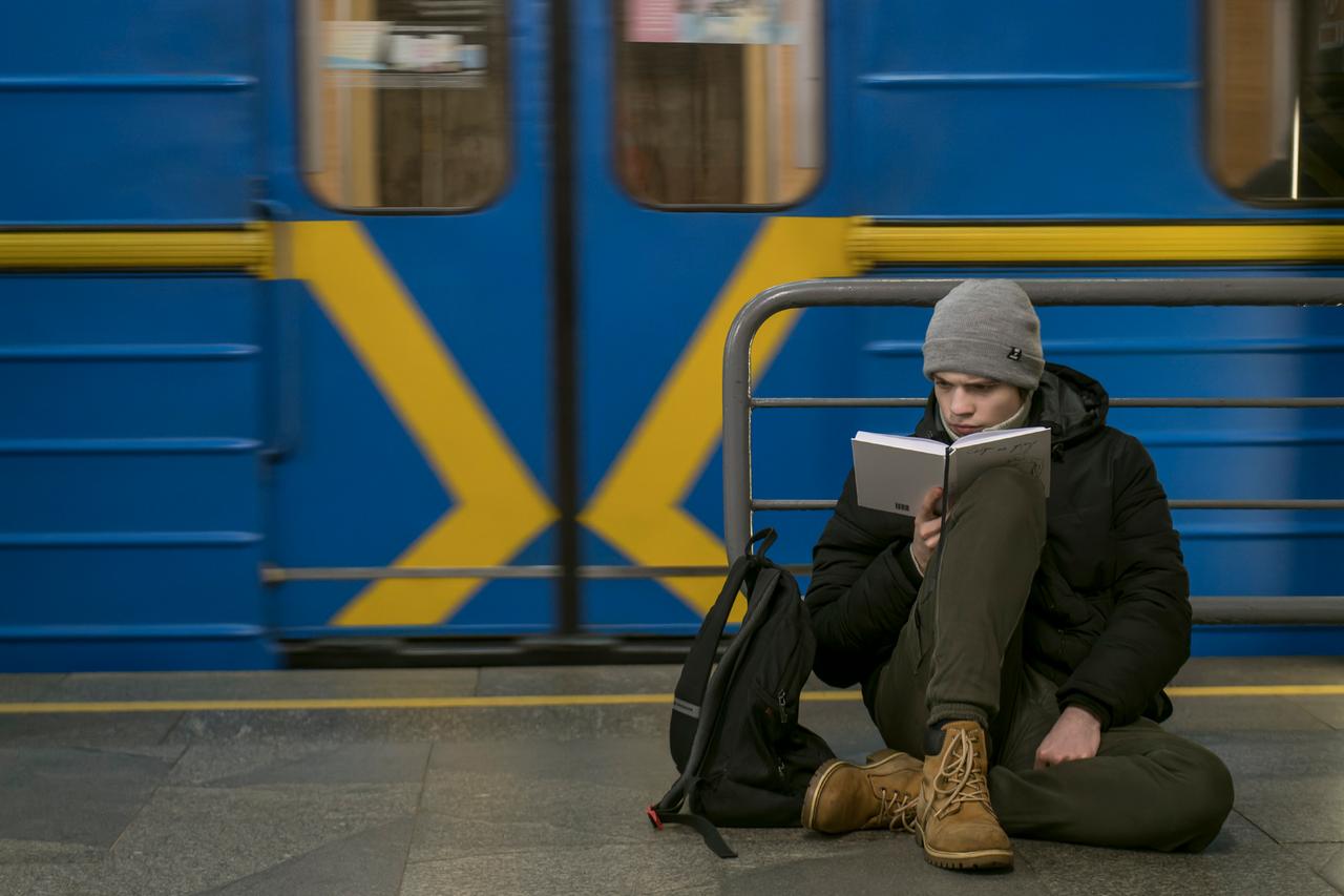 Ein Mann liest, während er in einer U-Bahn-Station in Kiew vor den russischen Luftangriffen Schutz gesucht hat.