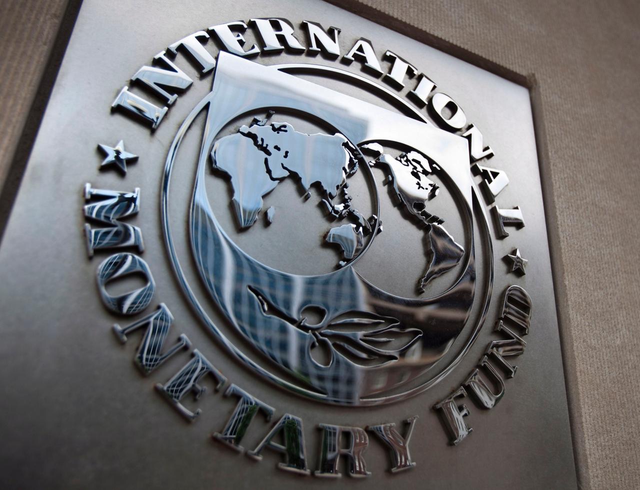 Die viereckige Metallplakette mit dem Logo des IWF an einer Wand.