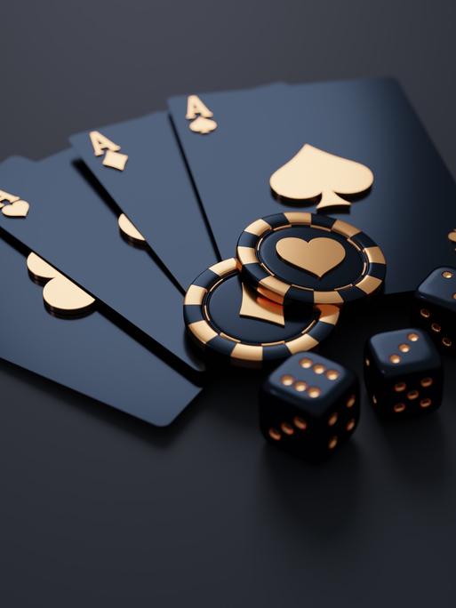 Edle schwarz-goldene Spielkarten (Asse), Spielchips und Würfel vor einem schwarzen Hintergrund