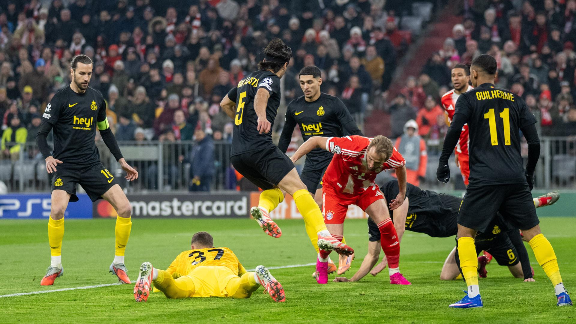 Champions League: Bayern Muenchen siegt gegen Union Saint Gilloise; Spieler beider Mannschaften kämpfen um den Ball.