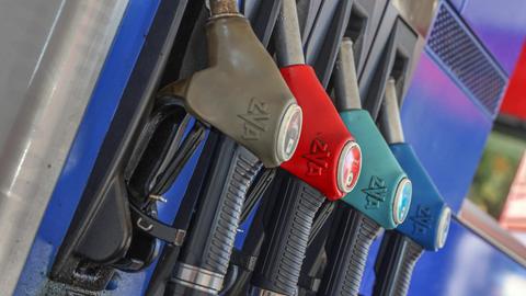 Eine Zapfsäule mit eingehängten Zapfpistolen an einer Tankstelle.