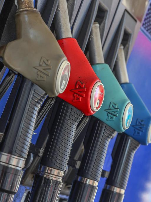 Eine Zapfsäule mit eingehängten Zapfpistolen an einer Tankstelle.