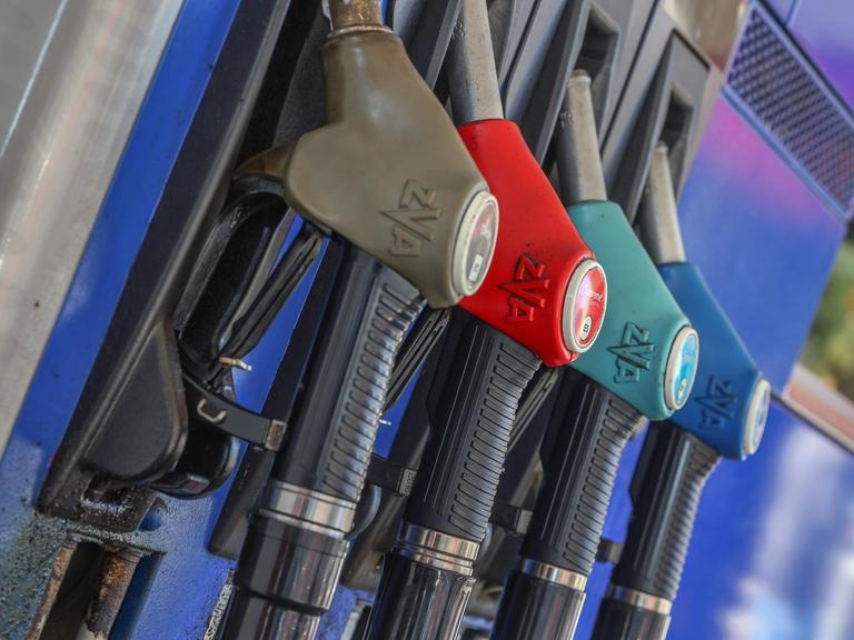 Eine Zapfsäule mit eingehängten Zapfpistolen an einer Tankstelle.