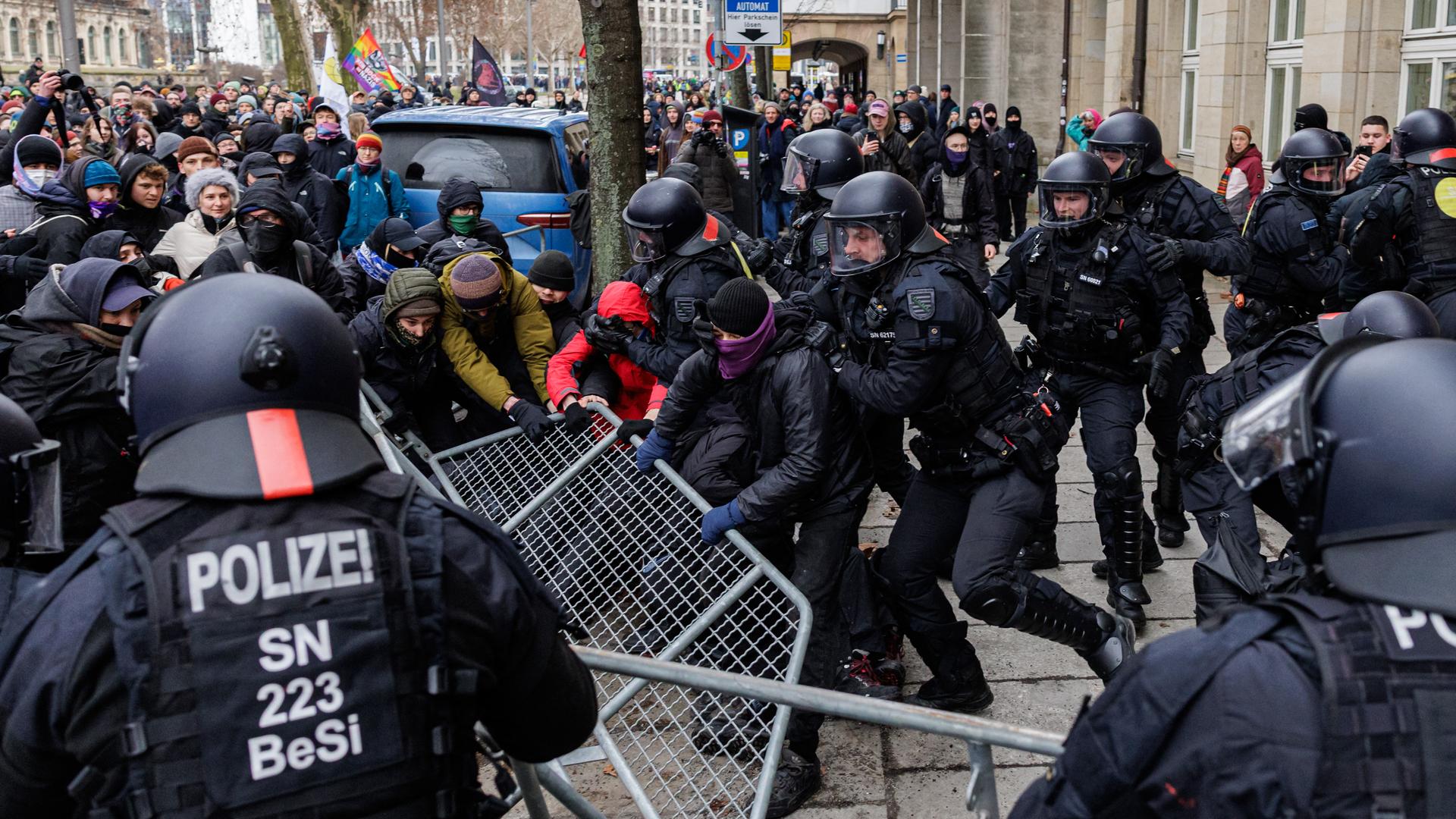 Polizisten hindern Teilnehmer einer linken Demonstration daran, einen Absperrzaun zu entfernen, während sie gegen einen geplanten Marsch von Rechtsextremisten in Dresden protestieren. Polizisten hindern Teilnehmer einer linken Demonstration daran, einen Absperrzaun zu entfernen, während sie gegen einen geplanten Marsch von Rechtsextremisten in Dresden protestieren.