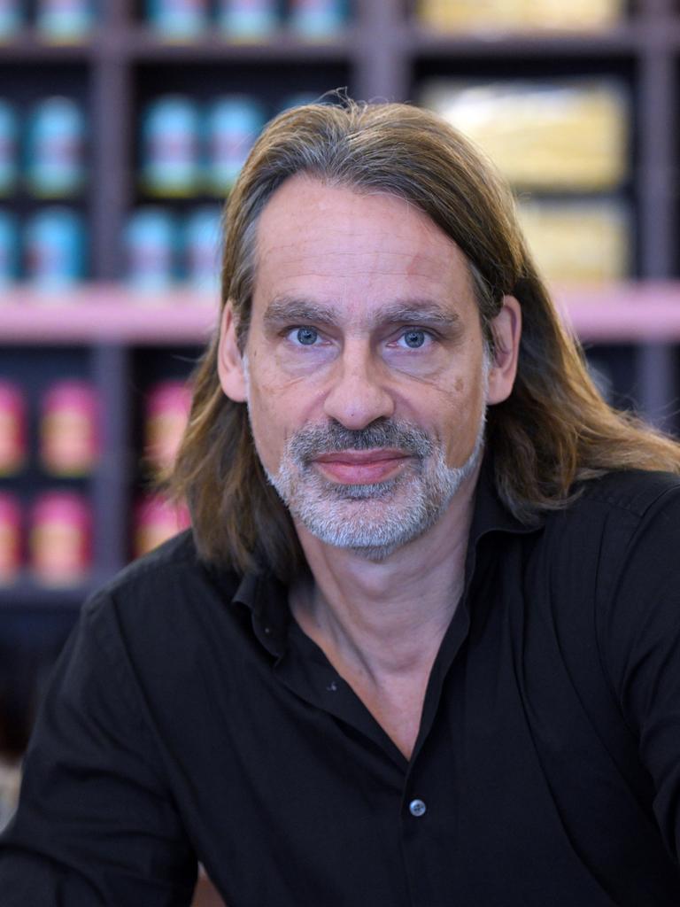 Richard David Precht blickt vor unscharfem Bildhintergrund ernst in die Kamera