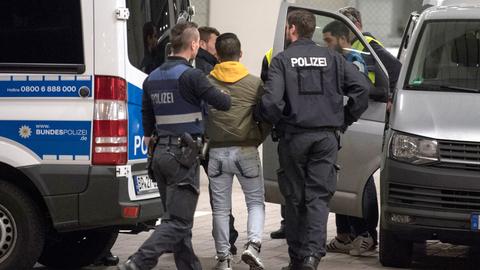 Hand- und Fußfesseln trägt ein junger Mann aus Afghanistan, den Polizisten zur Abschiebung zum Flughafen bringen.