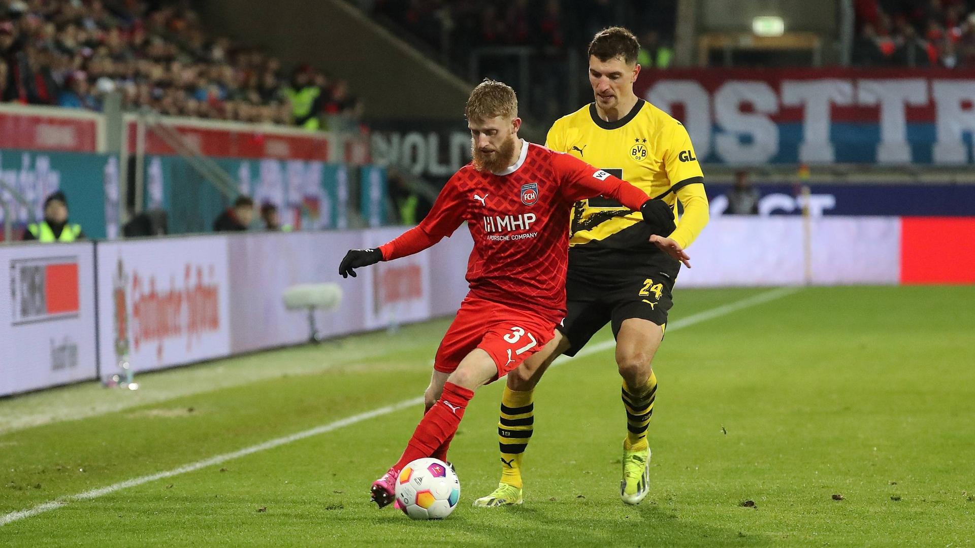 Der Heidenheimer Fußballspieler Jan-Niklas Beste schirmt den Ball gegen den Dortmunder Thomas Meunier ab.