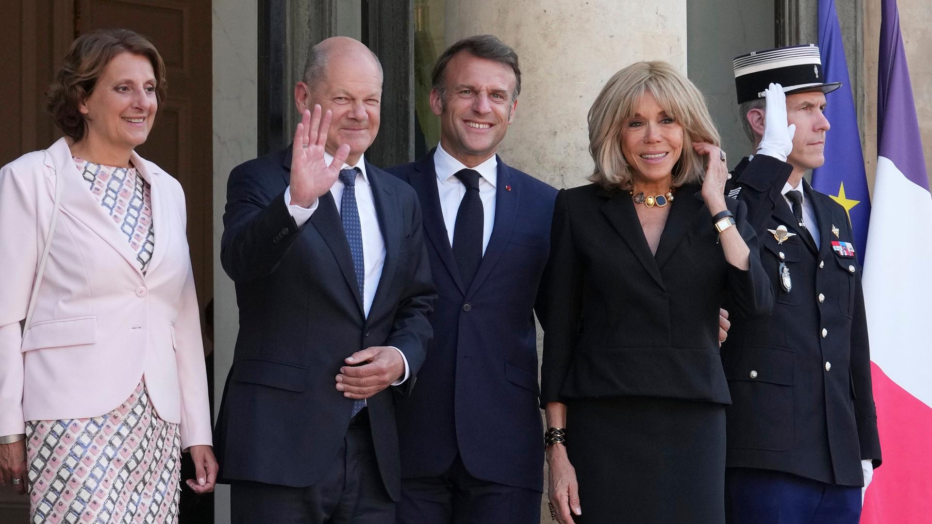 Der französische Präsident Emmanuel Macron (2.v.r-r) und seine Frau Brigitte Macron stehen mit dem deutschen Bundeskanzler Olaf Scholz (M,l) und seiner Frau Britta Ernst im Hof des Elysee-Palastes. 
