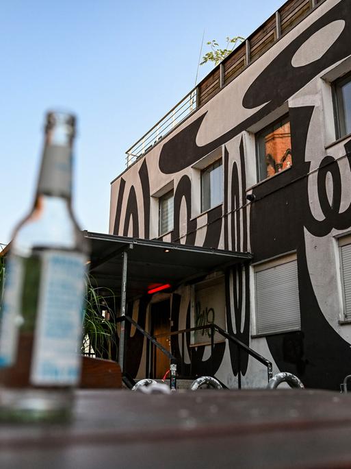 Der Watergate-Club in Kreuzberg. Im Vordergrund eine leere Flasche auf einem Tisch im Hof.