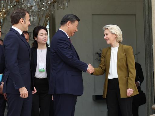 Der chinesische Präsident Xi Jingping und EU-Kommisionspräsidentin Ursula von der Leyen geben sich vor dem Élysée Palast in Paris die Hand. Links von ihnen ist Frankreichs Präsident Emmanuel Macron.