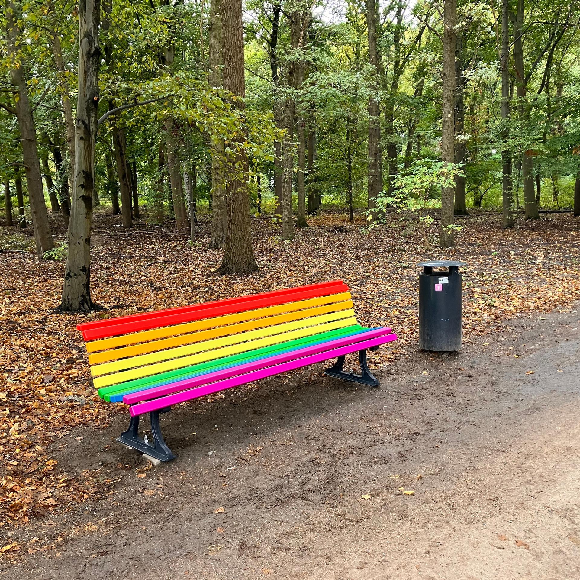 An der Gedenkstätte im Berliner Tiergarten, die an den islamistischen Terroranschlag am Christopher Street Day (CSD) erinnert, steht eine Sitzbank aus Holz in Regenbogenfarben.