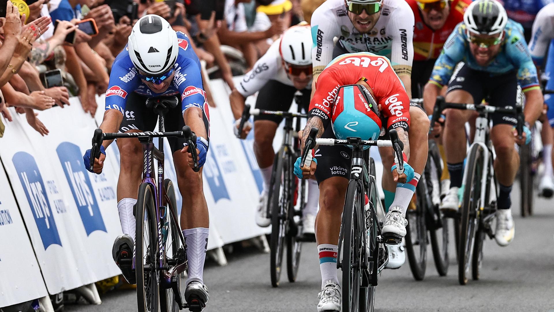 Zwei Radprofis überqueren bei der Tour de France die Ziellinie nach einem Sprint.