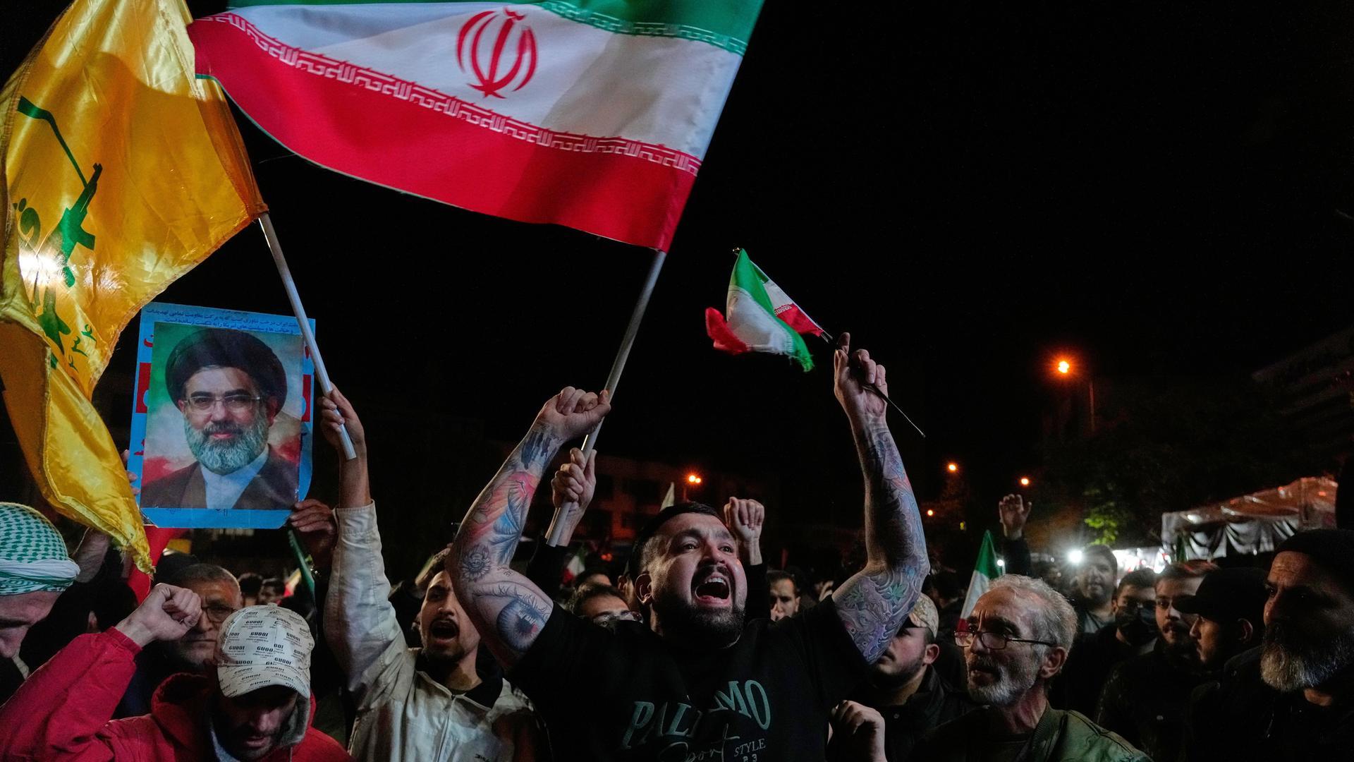 Iranische Pro-Regierungs-Demonstranten skandieren Slogans, während sie iranische Flaggen und ein Poster des Obersten Führers Chamenei halten. Sie versammeln sich nach der Ankündigung einer zweiwöchigen Waffenruhe im Krieg mit den USA und Israel. Iranische Pro-Regierungs-Demonstranten skandieren Slogans, während sie iranische Flaggen und ein Poster des Obersten Führers Chamenei halten. Sie versammeln sich nach der Ankündigung einer zweiwöchigen Waffenruhe im Krieg mit den USA und Israel.