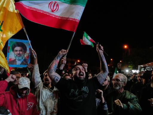 Iranische Pro-Regierungs-Demonstranten skandieren Slogans, während sie iranische Flaggen und ein Poster des Obersten Führers Chamenei halten. Sie versammeln sich nach der Ankündigung einer zweiwöchigen Waffenruhe im Krieg mit den USA und Israel. Iranische Pro-Regierungs-Demonstranten skandieren Slogans, während sie iranische Flaggen und ein Poster des Obersten Führers Chamenei halten. Sie versammeln sich nach der Ankündigung einer zweiwöchigen Waffenruhe im Krieg mit den USA und Israel.