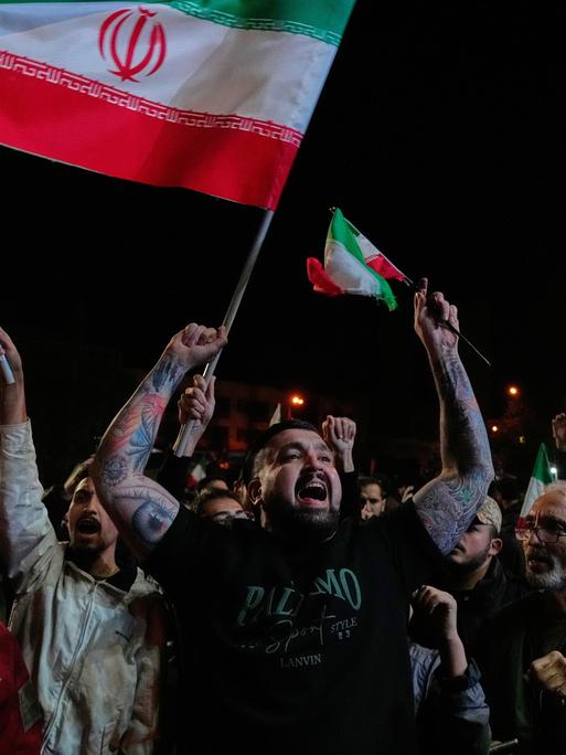 Iranische Pro-Regierungs-Demonstranten skandieren Slogans, während sie iranische Flaggen und ein Poster des Obersten Führers Chamenei halten. Sie versammeln sich nach der Ankündigung einer zweiwöchigen Waffenruhe im Krieg mit den USA und Israel. Iranische Pro-Regierungs-Demonstranten skandieren Slogans, während sie iranische Flaggen und ein Poster des Obersten Führers Chamenei halten. Sie versammeln sich nach der Ankündigung einer zweiwöchigen Waffenruhe im Krieg mit den USA und Israel.