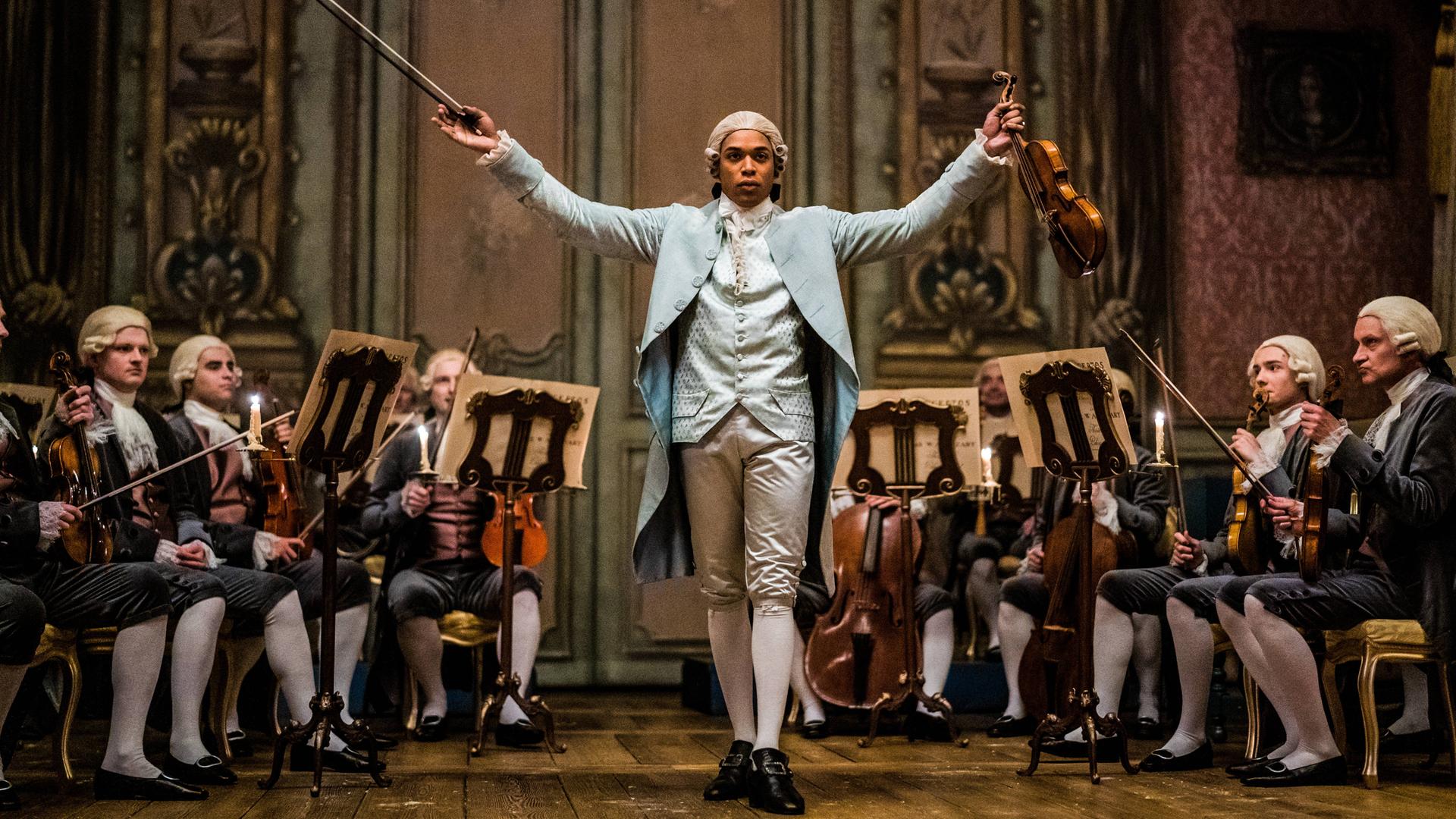 Ein Bild aus dem Film "Chevalier" zeigt das musikalische Wunderkind Joseph Bologne, Chevalier de de Saint-Georges, mit Geige und Taktstock.