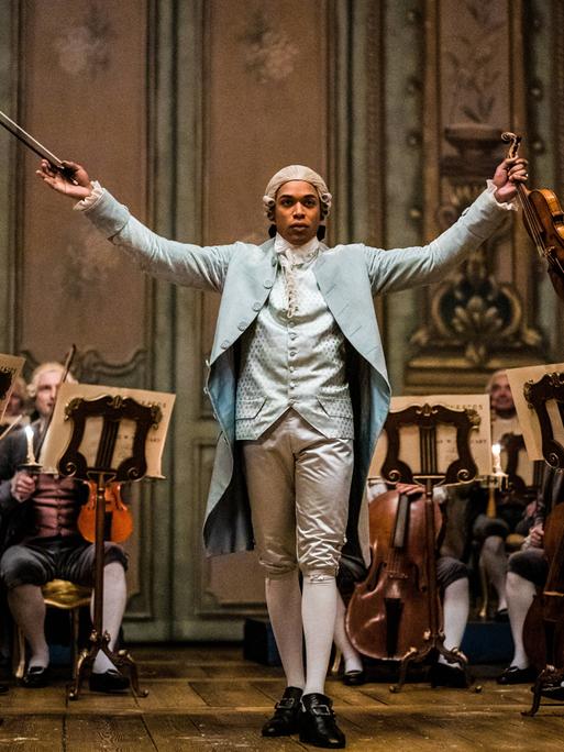 Ein Bild aus dem Film "Chevalier" zeigt das musikalische Wunderkind Joseph Bologne, Chevalier de de Saint-Georges, mit Geige und Taktstock.