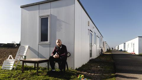 Mohanad al Saloun (30) ist mit seiner Familie aus Syrien geflüchtet und sitzt nun vor einem Container einer Flüchtlingsunterkunft in Hamminkeln in NRW. 