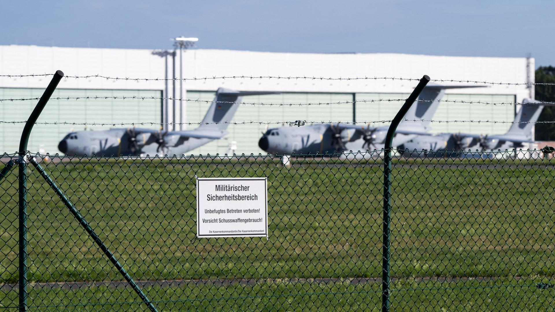 Drei Transportflugzeuge Airbus A400M der Luftwaffe der Bundeswehr stehen auf dem Fliegerhorst Wunstorf. Man sieht sie von außerhalb eines Zauns. Drei Transportflugzeuge Airbus A400M der Luftwaffe der Bundeswehr stehen auf dem Fliegerhorst Wunstorf. Man sieht sie von außerhalb eines Zauns.