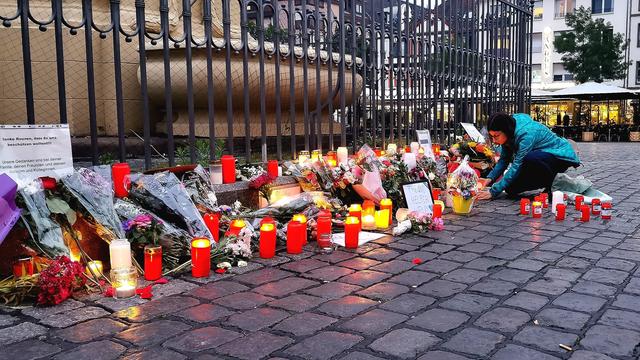 Menschen legen Kerzen und Blumen für den getöteten Polizisten auf den Markt-Platz von Mannheim.