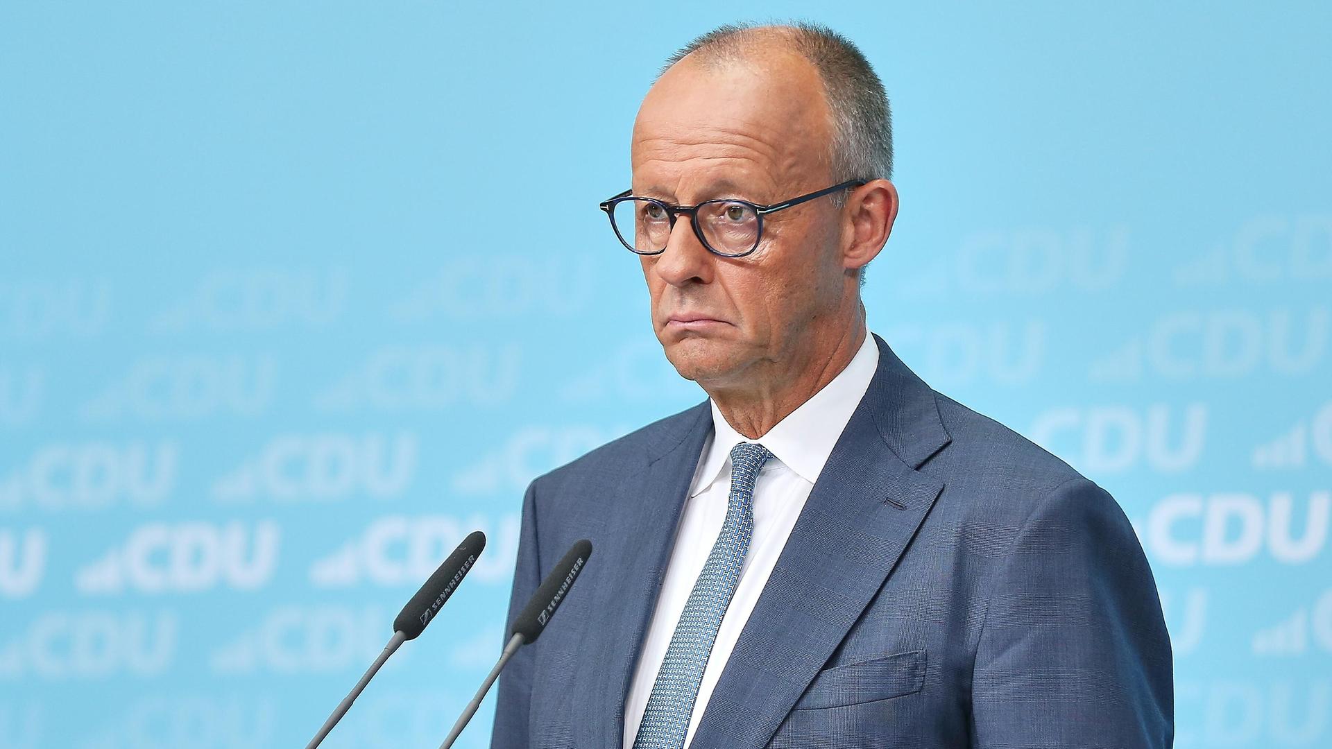 Bundeskanzler Friedrich Merz am Rednerpult im Konrad-Adenauer-Haus mit geschlossenem Mund und ernstem Gesichtsausdruck