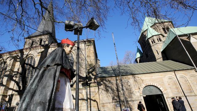 Das Foto zeigt den Dom in Essen und eine Statue von Kardinal Hengsbach. 