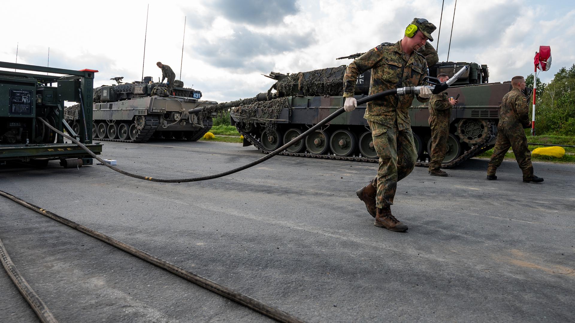 Soldaten der Bundeswehr betanken einen Kampfpanzer vom Typ Leopard 2 nach einer Übung.
