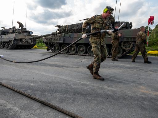 Soldaten der Bundeswehr betanken einen Kampfpanzer vom Typ Leopard 2 nach einer Übung.