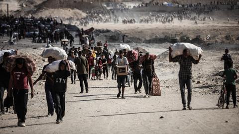 Palästinenser tragen am 5. Oktober 2025 Säcke und Kisten mit Nahrungsmittelhilfe durch den Gazastreifen in Netzarim, wo sich trotz der Gefahren Menschenmengen an einem Verteilungspunkt versammelten. Palästinenser tragen am 5. Oktober 2025 Säcke und Kisten mit Nahrungsmittelhilfe durch den Gazastreifen in Netzarim, wo sich trotz der Gefahren Menschenmengen an einem Verteilungspunkt versammelten.