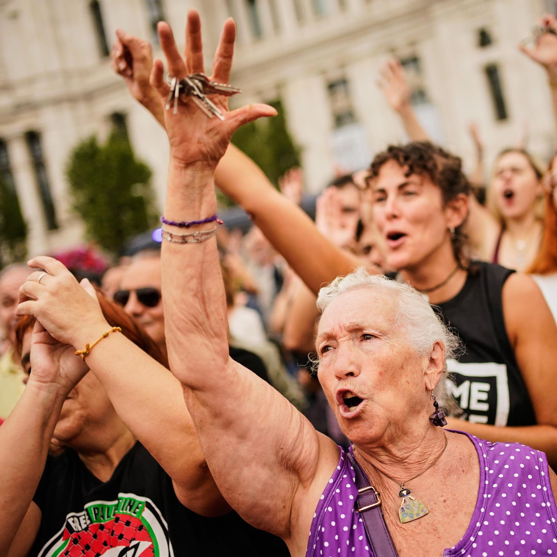 Menschen stehen dicht gedrängt bei einer Demonstration. Einige halten Schilder hoch. 