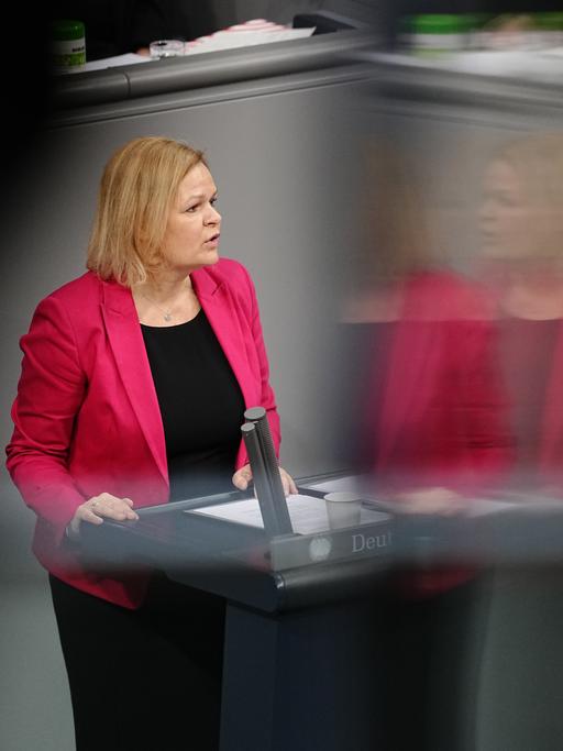 Bundesinnenministerin Nancy Faeser (SPD) am Rednerpult in einer Bundestagsdebatte. 