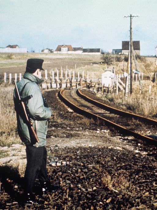Blick auf den Bahnübergang bei Dankmarshausen am 01.12.1967, der von den Behörden der DDR gesperrt wurde. Das Bild zeigt einen Beamten des Bundesgrenzschutzes vor dem Stoppschild und im Hintergrund die Sperrung der DDR.