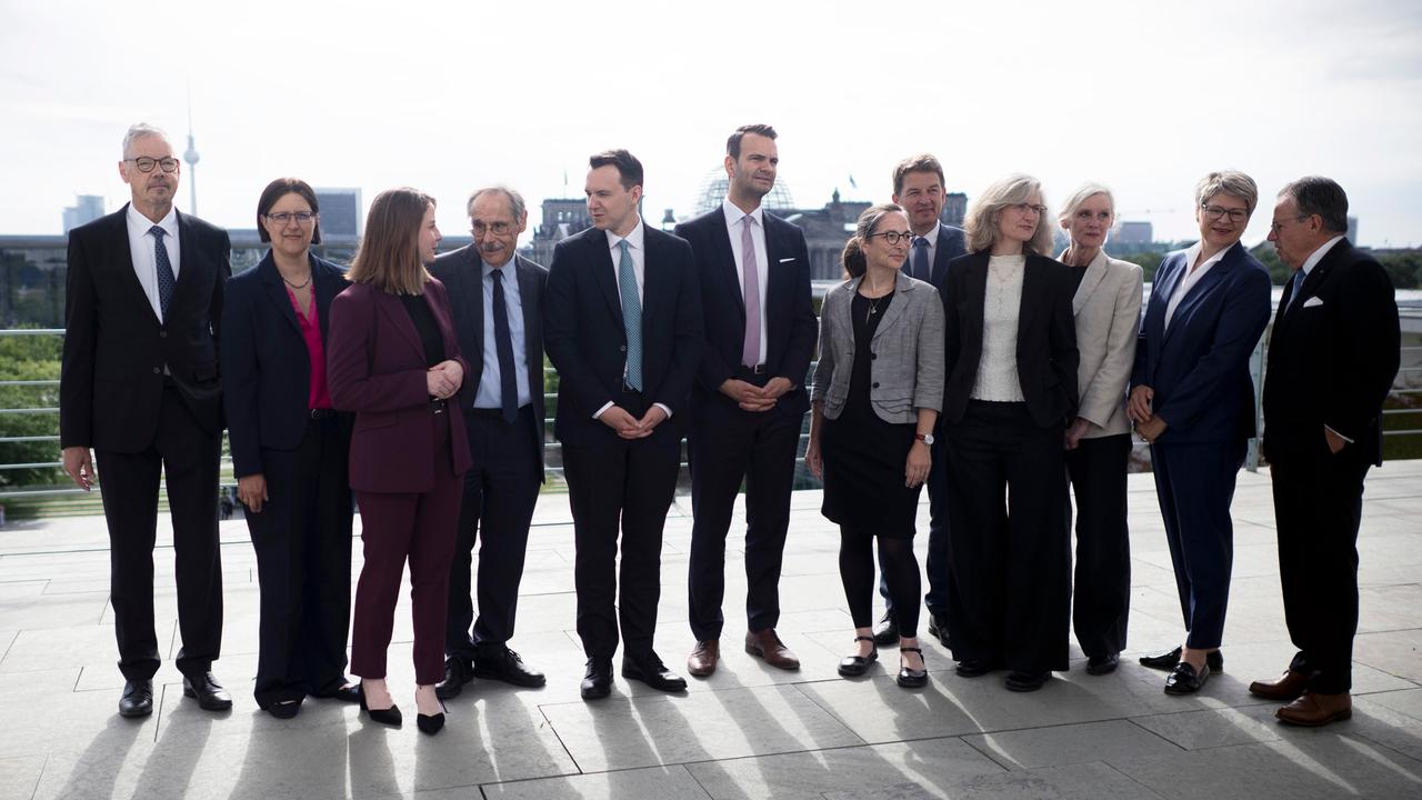 Die Vorsitzende Constanze Janda (6. von rechts) und weitere Mitglieder der Rentenkommission stehen auf dem Dach des Bundeskanzleramtes in Berlin, dahinter sieht man in der Ferne den Reichstag und den Fernsehturm.