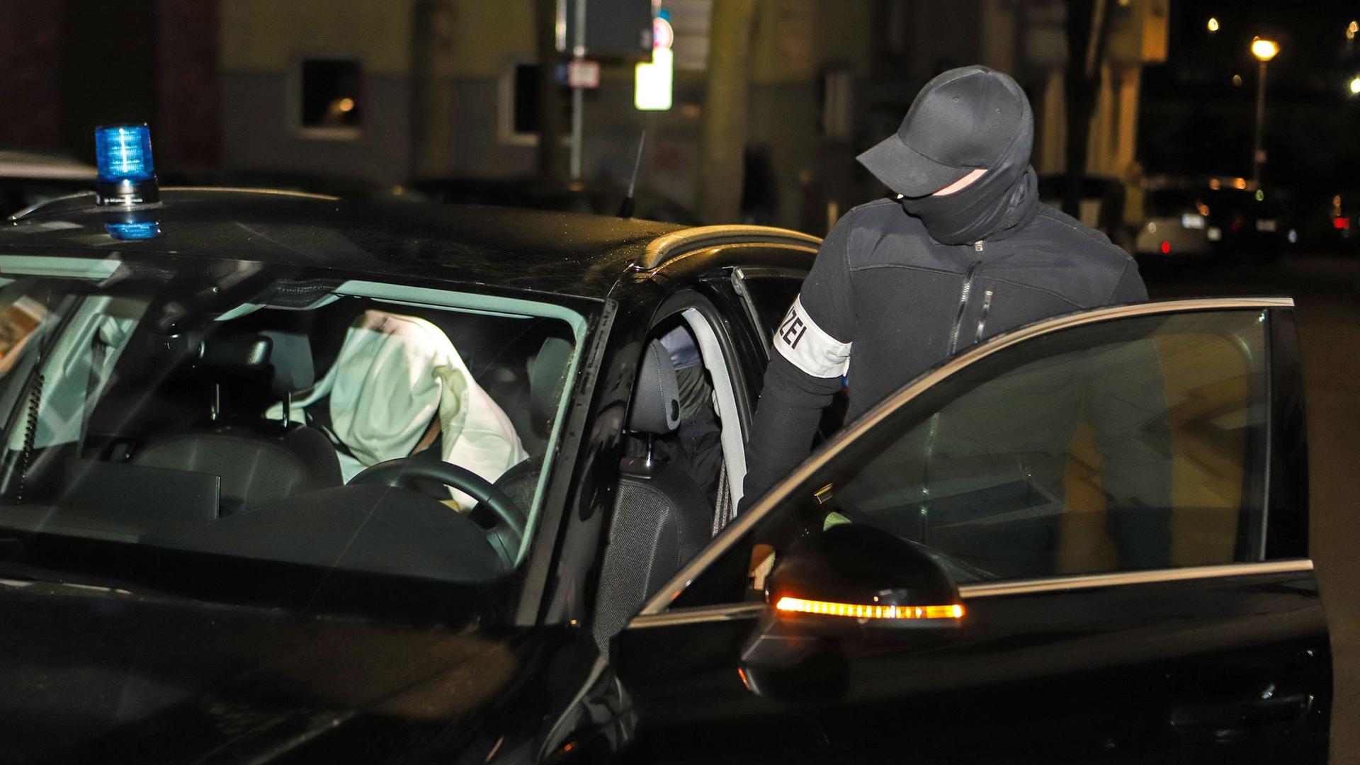 Ein Polizist steigt während einer Razzia in ein Auto in dem eine festgenommene Person sitzt. Mit einem Grosseinsatz in mehreren Bundesländern ist die Polizei gegen Mitglieder der italienischen Mafia "Ndrangheta" deutschlandweit vorgegangen, 3.Mai 2023.