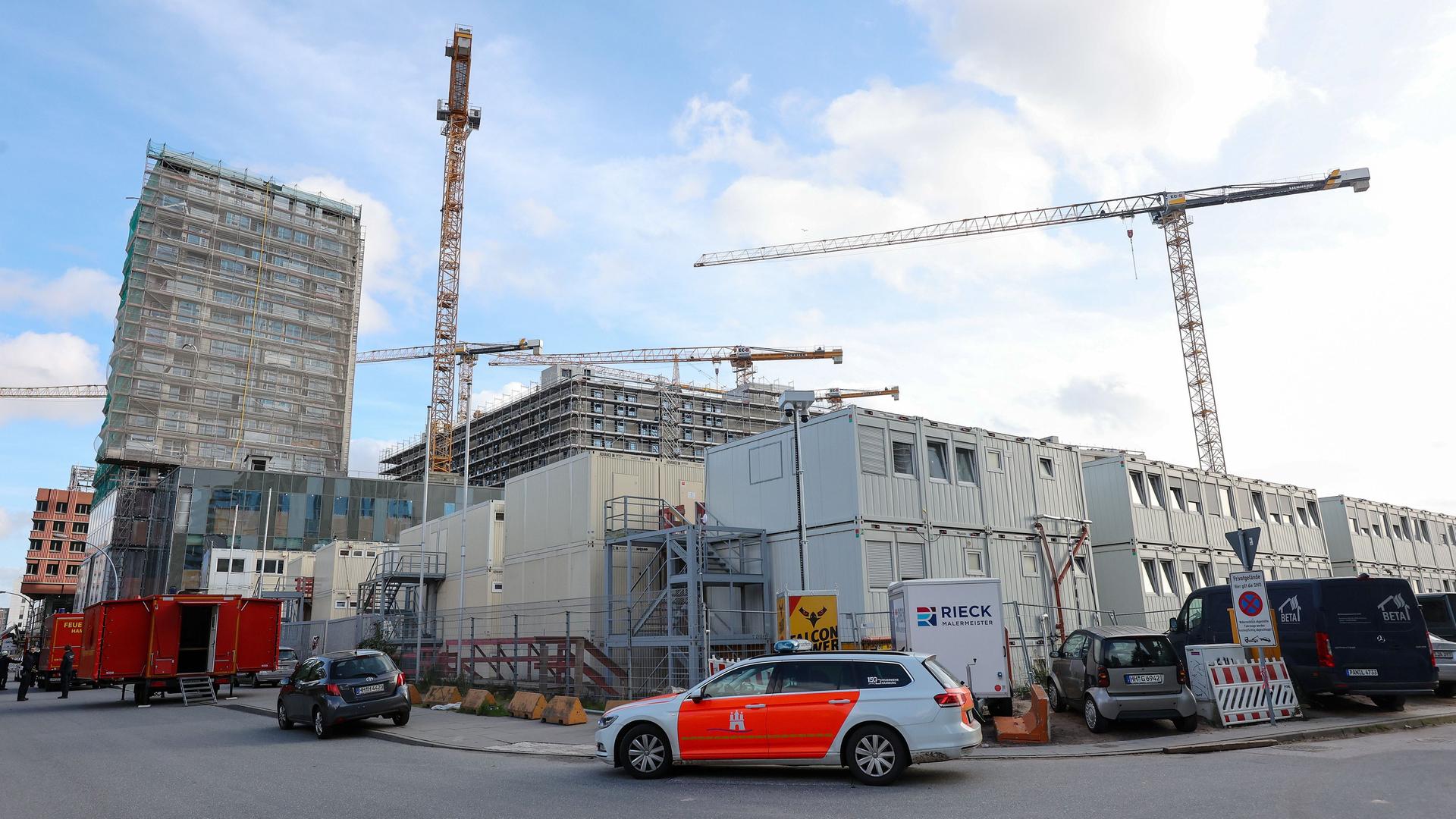 Hamburg: Einsatzfahrzeuge der Feuerwehr stehen vor einer Baustelle, auf der es einen schweren Unfall gab.