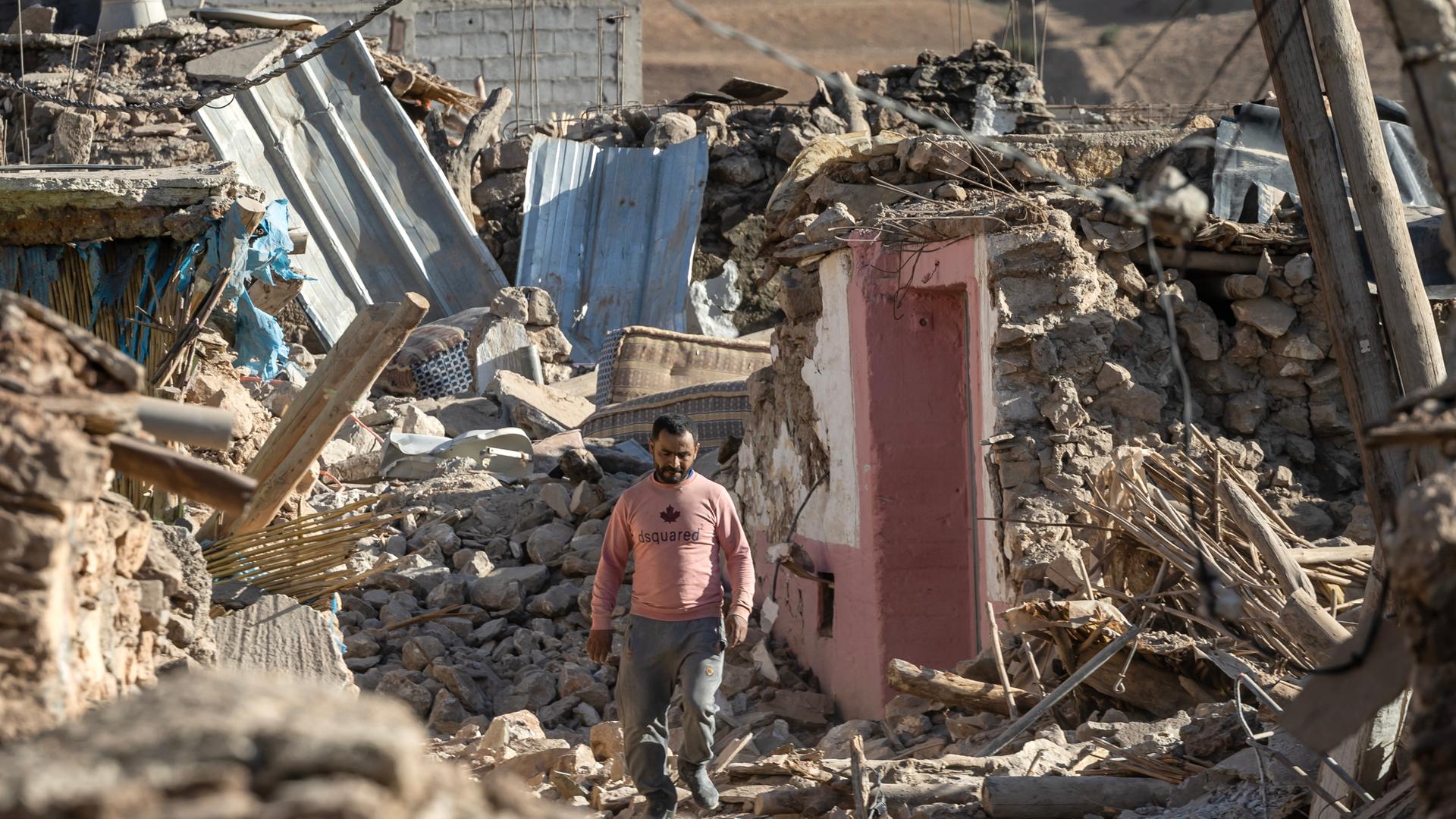 Ein Mann läuft an zerstörten Gebäuden im Dorf Tafeghaghte nahe Marrakesch vorbei nach dem Erdbeben in Marokko.