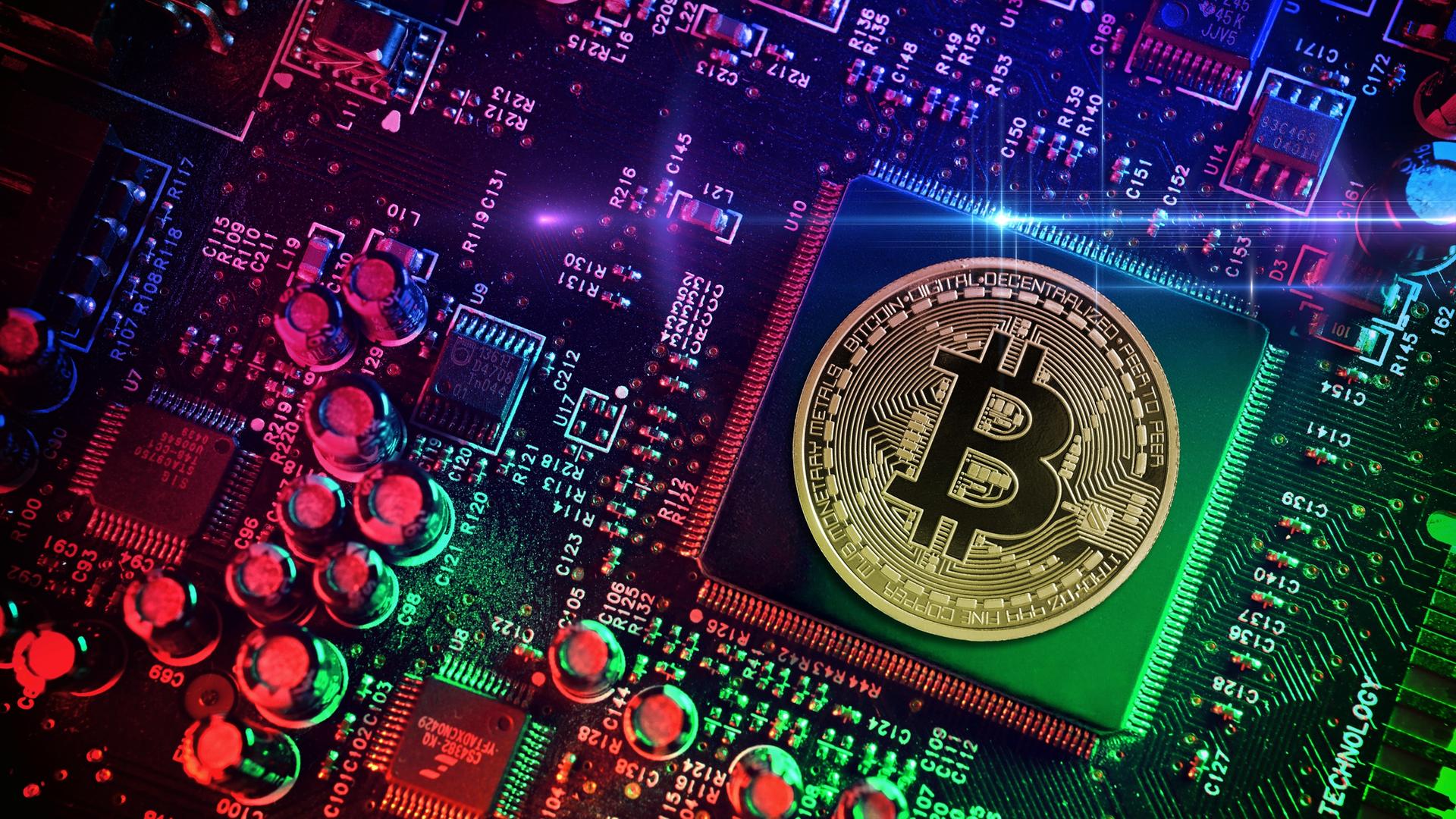 Computerchip mit Bitcoin-Münze, Symbolfoto Computerchip mit Bitcoin-Münze, Symbolfoto