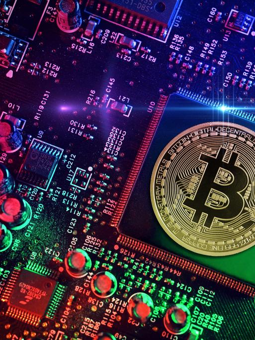 Computerchip mit Bitcoin-Münze, Symbolfoto Computerchip mit Bitcoin-Münze, Symbolfoto